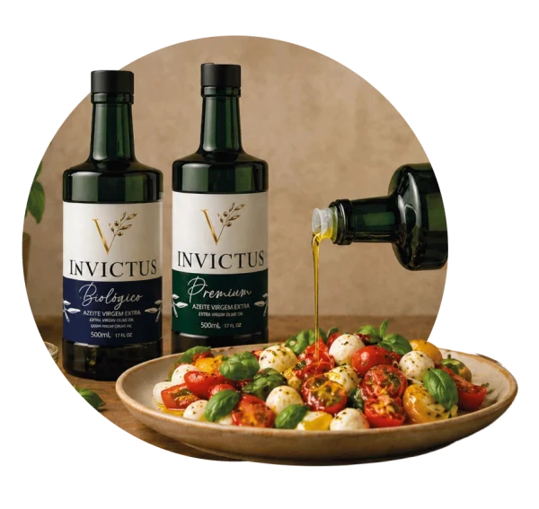 Garrafas de Azeite Virgem Extra Invictus Biológico e Premium ao lado de uma salada caprese, com fio de azeite a ser servido sobre tomates e mozarela